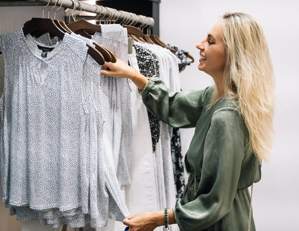 woman reaching for clothing in closet with matching hangers